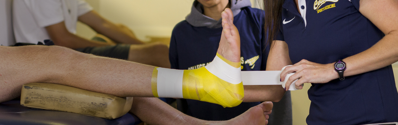 运动医学系为受伤的运动员包扎脚踝。