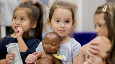 三个小女孩带着洋娃娃。
