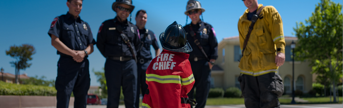 消防员微笑着与年轻的未来“消防队长”交谈。