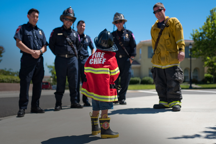 消防员微笑着与年轻的未来“消防队长”交谈。